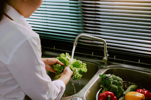 Asiático manos mujer lavado verduras ensalada y preparación comida saludable en cocina. - Foto, Imagen