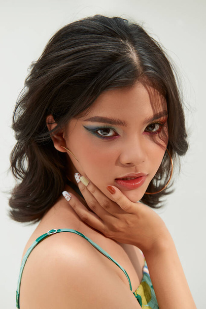Fashion shot. Portrait of a beautiful young woman in trendy makeup with rainbow eye arrows. Make-up and cosmetics. - 写真・画像