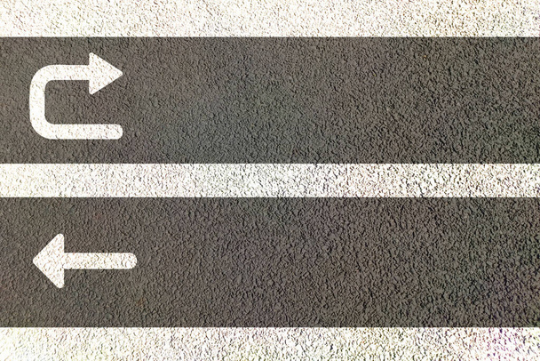 Setas em linha reta e em U pintadas na estrada para movimento direcional de tráfego em pistas vista superior da estrada de asfalto. - Foto, Imagem