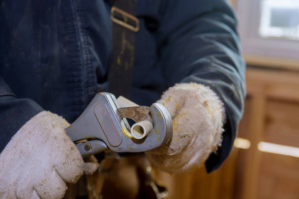 Manuale uomo taglia un pezzo di tubi in polipropilene per l'installazione linea d'acqua di una nuova casa in costruzione - Foto, immagini