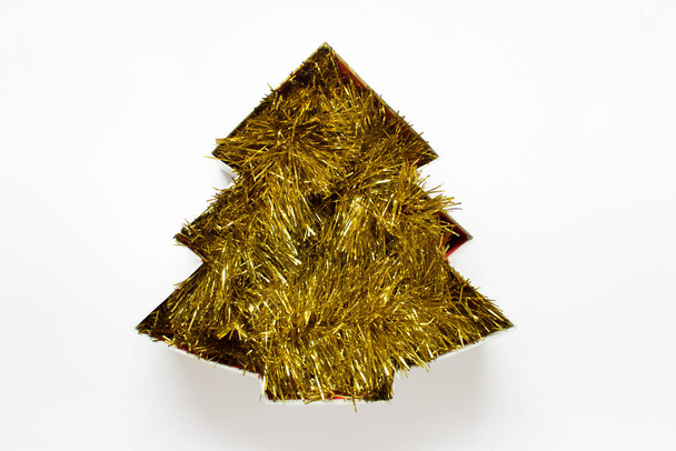 Christmas tree silhouette filled with sparkling golden garland on white background. - Foto, imagen