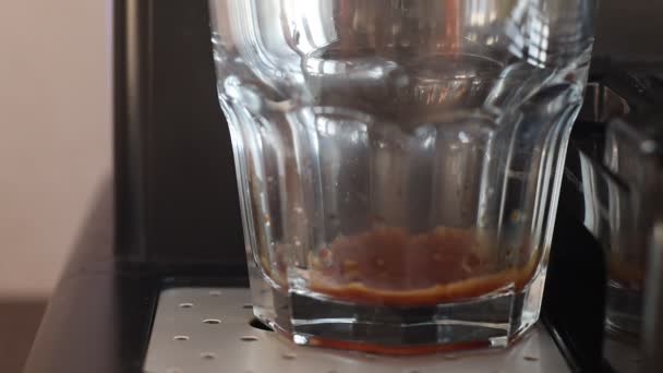Coffee machine pouring espresso coffee in a glass. Drinking fresh black coffee in the morning. Coffee machine making espresso in glass transparent coffee cup. - Footage, Video
