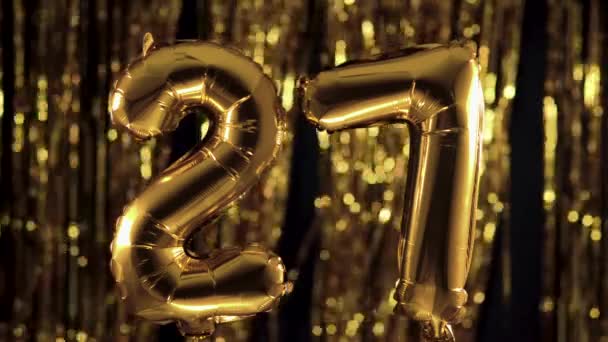 Złota liczba 27 dwadzieścia siedem jest wykonana z nadmuchiwanej piłki na żółtym tle. Jeden z kompletnych zbiorów liczb. Urodziny, rocznica, koncepcja daty - Materiał filmowy, wideo