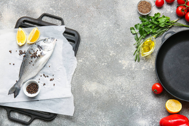 Сырая рыба Дорадо с ингредиентами на сером фоне - Фото, изображение