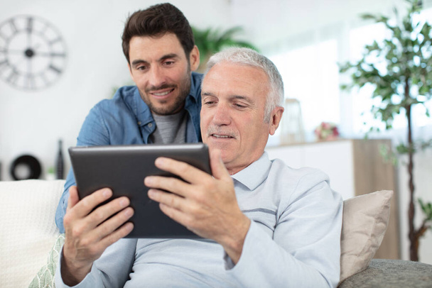 hipster son and his senior father with tablet at home - Photo, Image