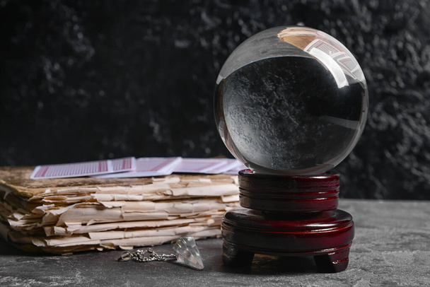 Crystal ball of fortune teller and old book on dark background - Fotó, kép