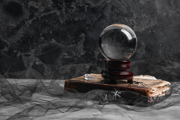 Boule de cristal de diseur de bonne aventure et vieux livre sur fond sombre - Photo, image