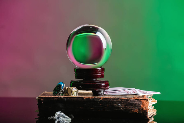 Boule de cristal de diseur de bonne aventure, vieux livre et cartes sur la table - Photo, image