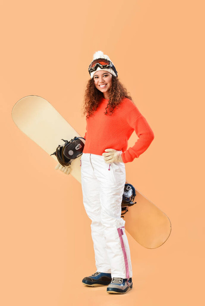 Female snowboarder on color background - Φωτογραφία, εικόνα