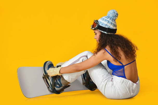 Female snowboarder on color background - Foto, afbeelding