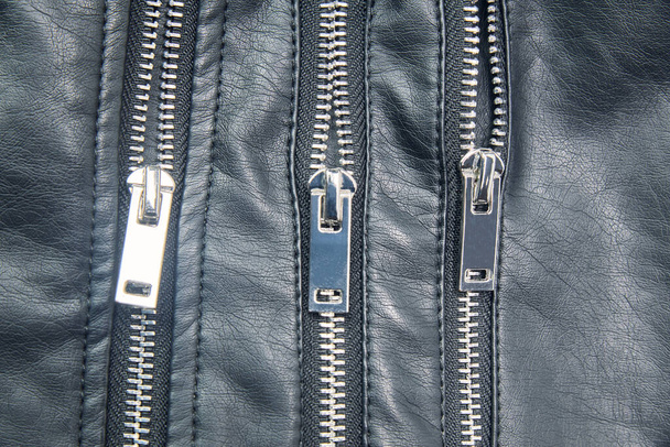 Detalle de las cremalleras metálicas de la clásica chaqueta de cuero negro. Concepto de moda para hombres y mujeres - Foto, imagen
