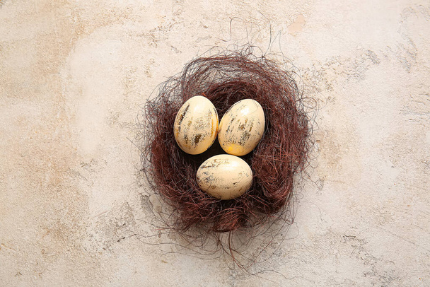 Nido con hermosos huevos de Pascua sobre fondo claro - Foto, Imagen
