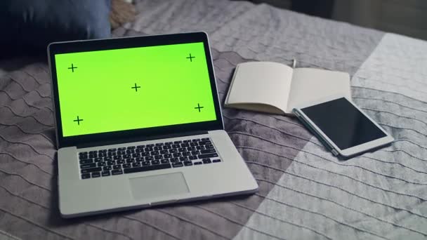 Un computer portatile aperto si trova sul letto in un interno domestico. Schermo verde con marcatori di tracciamento. - Filmati, video