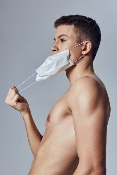 deporte chico poniendo en médico máscara en la cara de protección recortado vista de la salud  - Foto, Imagen