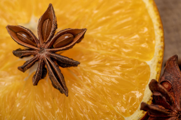 Half an orange and a star anise on a wooden table. Close-up, selective focus. - Фото, зображення