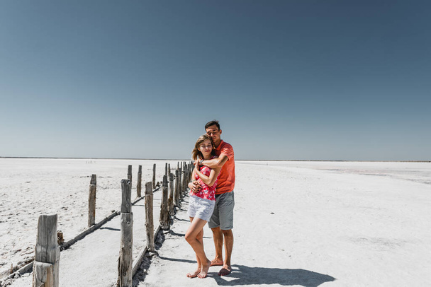 lovers in the desert. couple walks along the trail. the road to the far. a guy with a girl in a non-forged place date of a young couple. white desert - Foto, Imagen