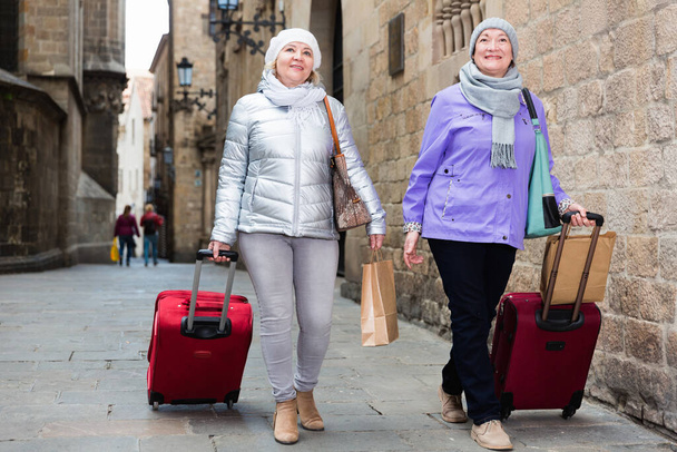 Senior females walking with baggage on city - Fotó, kép