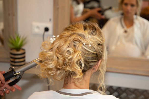 jolie femme blonde bouclée obtenir belle coiffure dans salon de coiffure coiffeur - Photo, image