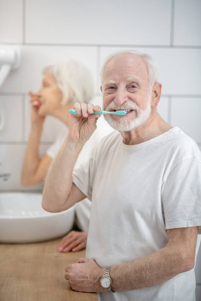 Senior couple brushing their teeth together in the bathroom - Photo, image