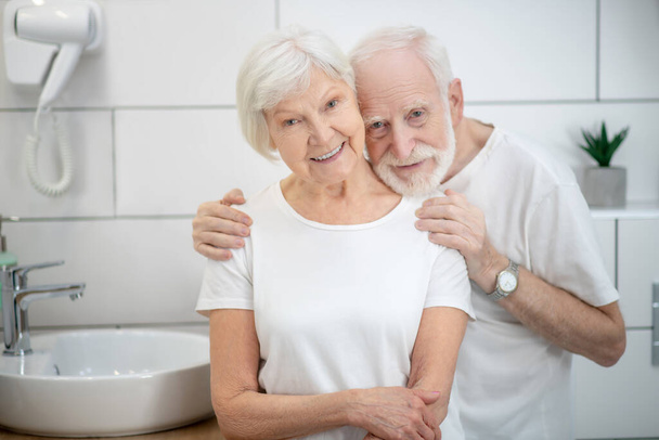 Elderly couple in the bathroom looking happy and smiling - Φωτογραφία, εικόνα