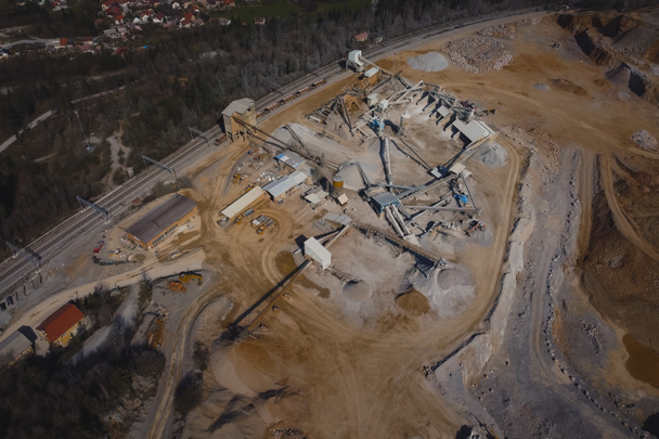 Panorama aéreo de uma mina aberta ou pedreira em um dia ensolarado em Verd, Eslovênia. Terraços visíveis e vasta superfície de areia e pedras, com edifícios de triagem em primeiro plano - Foto, Imagem