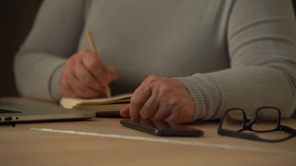 Lähikuva ryppyinen miesten kädet kirjallisesti tietoja. Vanha kypsä nainen työskentelee toimistossa, tietokoneella, käsiala muistiinpanoja - Materiaali, video