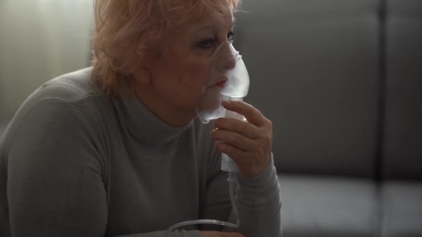 Kranke ältere Frau inhaliert, ältere Frau und Vernebler - Filmmaterial, Video