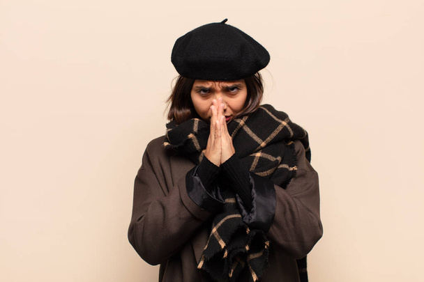 hispanic woman feeling worried, hopeful and religious, praying faithfully with palms pressed, begging forgiveness - Φωτογραφία, εικόνα