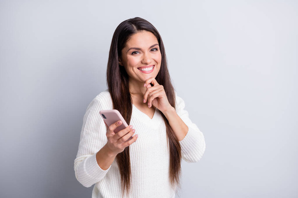 Portrait of charming cheerful brown-haired girl using gadget creating post smm media isolated over grey pastel color background - Foto, afbeelding