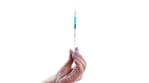 Vývoj vakcíny. Lékařská ruka v lékařské rukavici držte injekční stříkačku s jehlou na ochranu proti viru chřipky a koronaviru. Covidní vakcína izolovaná na bílo. Zdravotní péče v nemocnici - Fotografie, Obrázek