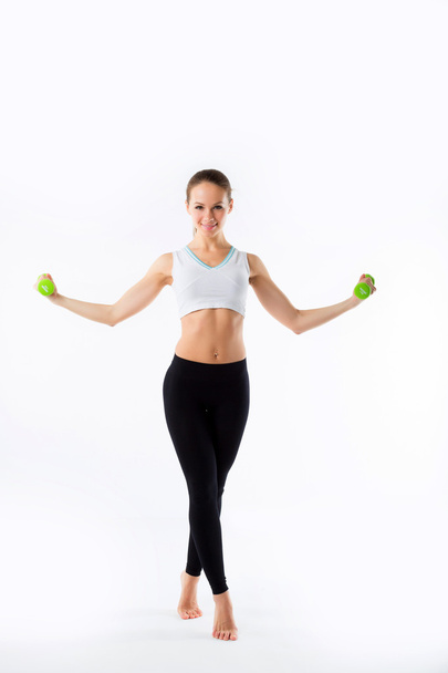 Young girl with dumbbells on a white background - Foto, afbeelding