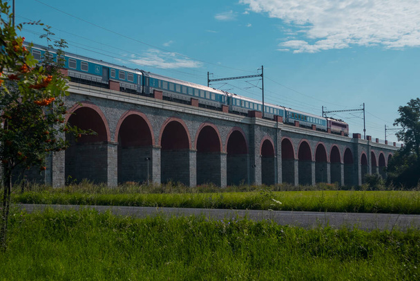チェコ共和国のJezernick ViaductまたはViaductの眺め、晴れた日には谷の上にアーチ型のアーチ型のヴィアドュークがあり、旅客列車が運転しています。. - 写真・画像