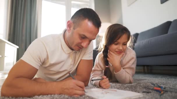 Father and daughter communicate, having fun and painting together. Concept of a happy family and quality leisure time - Footage, Video