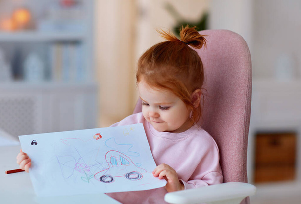 niedliches Kleinkind Baby Mädchen zeigt ihre Zeichnung, die mit Buntstiften gemacht wurde - Foto, Bild