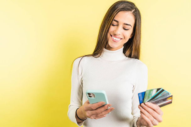 Jonge vrouw houdt credit card kopen online met smartphone - Foto, afbeelding