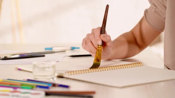 vista parcial de la mujer pintando sobre papel con pincel - Imágenes, Vídeo