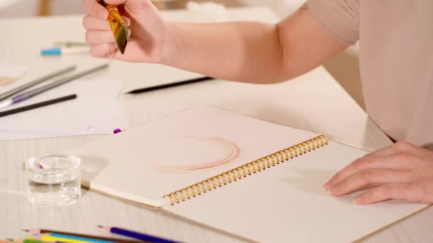 vista ritagliata di pittura donna su carta con pennello e vernice ad acquerello  - Filmati, video