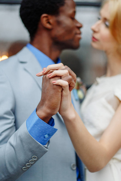 An interracial lover holding hands. Hands close-up. African man and white woman - 写真・画像