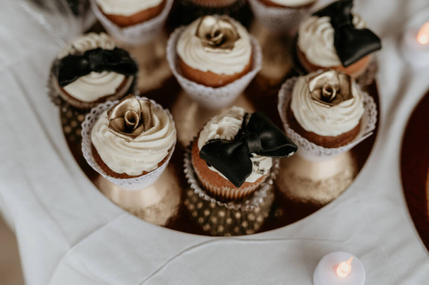 A selective focus shot of delicious cupcakes with flower and bow decorations - Foto, imagen