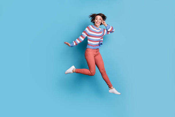 Full length body size photo of jumping high young girl showing gesture v-sign two fingers isolated on vibrant blue color background - Photo, Image