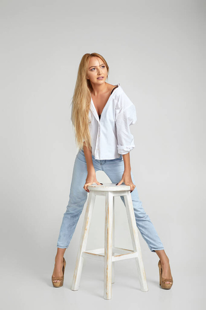 женщина с длинными волосами в джинсах и белой рубашкой - Фото, изображение
