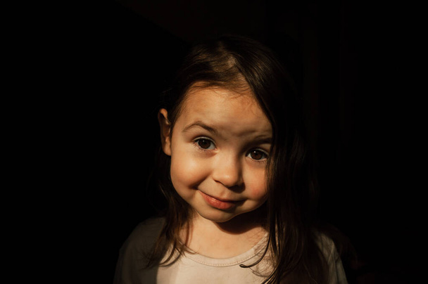 暗い背景で家庭での子供の肖像画 - 写真・画像