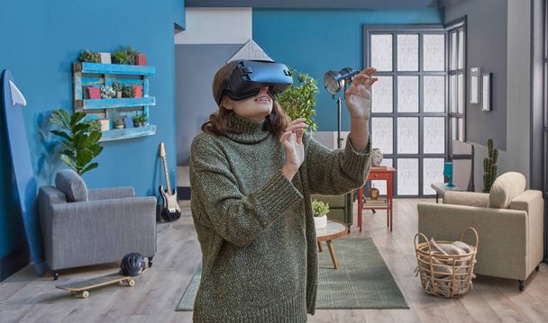 Девушка носить очки виртуальной реальности, закрыть, синяя гостиная зеленый диван украшения фона. - Фото, изображение