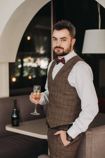 Portrait of handsome man in business suit holds glass . - Zdjęcie, obraz