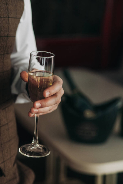 Close-up of a glass of champagne in the hand of a brutal businessman - Valokuva, kuva