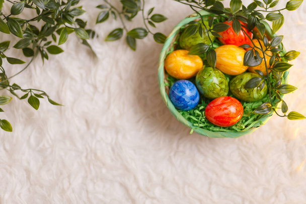 Velikonoční přání. Plochá skladba s velikonočními vejci v košíku na bílém pozadí. Horní pohled - Fotografie, Obrázek