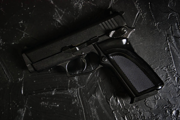 Pistola en mesa de textura negra. - Foto, Imagen