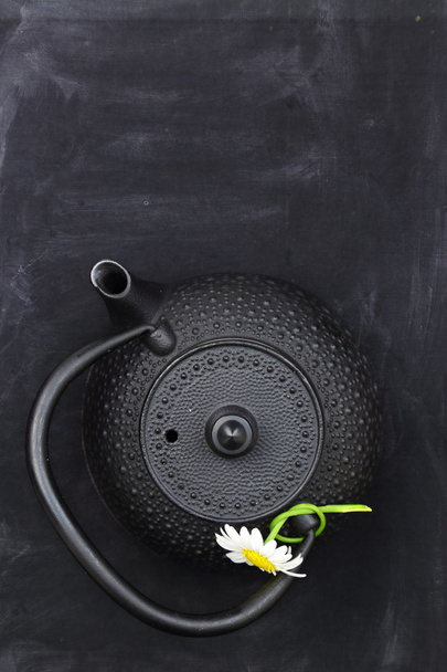 Teapot with chamomile on chalkboard top shot and copy-space - Photo, Image