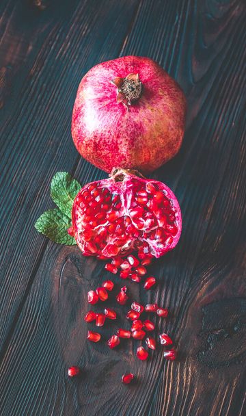 Fresh pomegranate on the wooden table: cross section - Foto, immagini