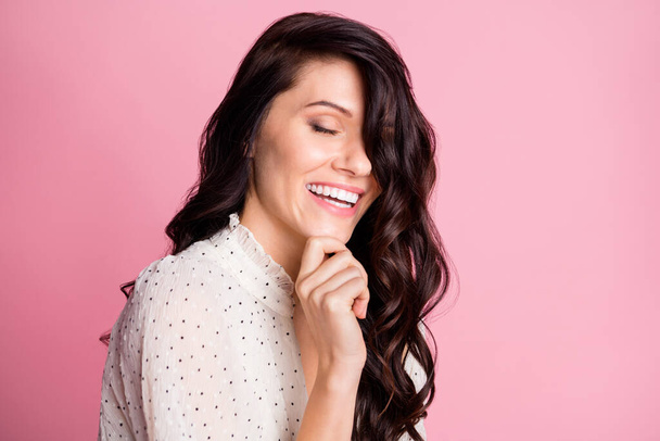 Photo portrait of dreamy overjoyed woman with wavy brunette hair laughing touching chin isolated pastel pink color background - Photo, Image